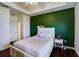 Comfortable bedroom featuring a tray ceiling, hardwood floors, and a bright green accent wall at 4802 51 W St # 1017, Bradenton, FL 34210