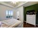 Comfortable bedroom featuring a large window, tray ceiling, hardwood floors and bright green accent wall at 4802 51 W St # 1017, Bradenton, FL 34210