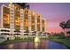 Elegant condo building featuring private balconies, lush landscaping and a picturesque water view with fountain at 501 Haben Blvd # 204, Palmetto, FL 34221