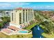 Upscale condo building exterior view shows multiple balconies, a pool, a water fountain, and manicured greenery at 501 Haben Blvd # 204, Palmetto, FL 34221
