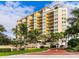 Luxury condo building with palm trees and beautifully landscaped grounds at 501 Haben Blvd # 204, Palmetto, FL 34221