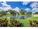 Beautiful pond with fountains, lush greenery, and mature trees reflecting in the water at 501 Haben Blvd # 204, Palmetto, FL 34221