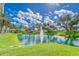 Scenic pond with a fountain surrounded by lush landscaping and a clear blue sky at 501 Haben Blvd # 204, Palmetto, FL 34221