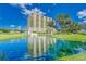 Luxury condo building with a serene pond and fountain at 501 Haben Blvd # 204, Palmetto, FL 34221