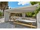 Shaded picnic area at Siesta Beach featuring wooden picnic tables under a modern concrete shelter, perfect for Gathering gatherings at 514 Ralph St, Sarasota, FL 34242