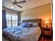 Bright bedroom with a ceiling fan, large window allowing for natural light, and a bedside table at 5631 Rosehill Rd. Rd # 203, Sarasota, FL 34233