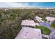Aerial view of the home in a lush, green, tree-filled neighborhood near a pond on a sunny day with blue skies and light clouds at 5688 Lake Vista Ct # 31, Sarasota, FL 34233