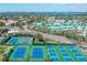 Aerial view of tennis courts and nearby residential community and cityscape in the distance at 5780 Midnight Pass Rd # 210, Sarasota, FL 34242
