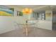 Dining area featuring a glass table and chairs, open to the kitchen with modern lighting at 5780 Midnight Pass Rd # 210, Sarasota, FL 34242