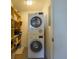 Convenient laundry room featuring a stacked washer and dryer with storage shelving at 5780 Midnight Pass Rd # 210, Sarasota, FL 34242