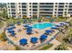 Aerial view of the community pool area with ample seating, umbrellas, and manicured landscaping at 5780 Midnight Pass Rd # 210, Sarasota, FL 34242