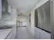 Contemporary kitchen featuring stainless steel appliances, white cabinets, quartz countertops, and tiled floors at 5780 Midnight Pass Rd # 210, Sarasota, FL 34242