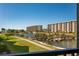 Scenic view from the condo overlooking lush landscaping, a tranquil lake, and the sparkling community pool at 5780 Midnight Pass Rd # 210, Sarasota, FL 34242