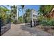 Elegant two-story home with a brick driveway, black iron gate and lush tropical landscaping at 601 Avenida De Mayo, Sarasota, FL 34242