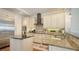 Well-equipped kitchen boasts white cabinets, granite countertops, stainless steel appliances, and hardwood floors at 601 Avenida De Mayo, Sarasota, FL 34242