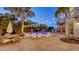 A relaxing backyard pool area with comfortable seating, lush landscaping, and ambient string lights at 601 Avenida De Mayo, Sarasota, FL 34242