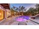 Outdoor oasis featuring a pool with evening lighting, lounge chairs, fountain and lush tropical landscaping at 601 Avenida De Mayo, Sarasota, FL 34242