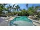Inviting pool area featuring a freeform pool, comfortable lounge seating and meticulously maintained tropical landscaping at 601 Avenida De Mayo, Sarasota, FL 34242