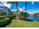 Lush backyard with mature landscaping, view of the lake and screened-in pool at 7015 Stanhope Pl, University Park, FL 34201