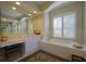 Elegant bathroom featuring a soaking tub framed by columns and ample vanity space with neutral-toned finishes at 7015 Stanhope Pl, University Park, FL 34201