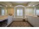 Elegant bathroom featuring a soaking tub framed by columns and ample vanity space with neutral-toned finishes at 7015 Stanhope Pl, University Park, FL 34201