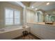 Elegant bathroom featuring a soaking tub framed by columns and ample vanity space with neutral-toned finishes at 7015 Stanhope Pl, University Park, FL 34201