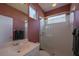 Bright bathroom with glass-enclosed shower, modern fixtures, and patterned wallpaper at 7015 Stanhope Pl, University Park, FL 34201
