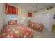 Charming bedroom with twin beds, floral bedding, and a ceiling fan for added comfort at 7015 Stanhope Pl, University Park, FL 34201