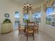 Cozy breakfast nook with large windows and a chandelier above the glass-topped table at 7015 Stanhope Pl, University Park, FL 34201