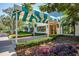 Charming building entrance with blue and white awning, lush landscaping, and brick walkway at 7015 Stanhope Pl, University Park, FL 34201