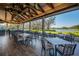 Spacious outdoor dining area with tables, chairs, and a beautiful view of the lake and trees at 7015 Stanhope Pl, University Park, FL 34201