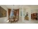 Elegant dining area featuring a decorative chandelier, large windows, and stylish furniture at 7015 Stanhope Pl, University Park, FL 34201