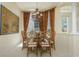 Elegant dining room with a chandelier, large windows with decorative drapes, and seating for eight at 7015 Stanhope Pl, University Park, FL 34201