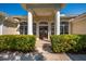 Close-up of the front entrance showcasing large columns, arched windows, and manicured greenery at 7015 Stanhope Pl, University Park, FL 34201