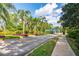 Community entrance with palm trees, flower beds, and a guard house, providing security and a welcoming entrance at 7015 Stanhope Pl, University Park, FL 34201