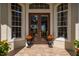 Close up on a double door entry framed by large arched windows and adorned with decorative flower pots at 7015 Stanhope Pl, University Park, FL 34201