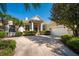 Charming house with a well-kept lawn, palm trees, and an elegant entrance with grand columns at 7015 Stanhope Pl, University Park, FL 34201