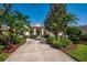 Beautiful home featuring a well-manicured lawn, decorative palms, and a long driveway leading to a welcoming entrance at 7015 Stanhope Pl, University Park, FL 34201