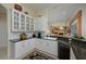 Bright kitchen with sleek black appliances, white cabinets, bar top with granite counters and view to the living room at 7015 Stanhope Pl, University Park, FL 34201