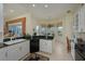 Stylish kitchen featuring sleek black appliances, white cabinets, a cozy breakfast nook and a breakfast bar at 7015 Stanhope Pl, University Park, FL 34201