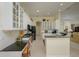 Bright kitchen with sleek black appliances, white cabinets, bar top with granite counters and breakfast nook at 7015 Stanhope Pl, University Park, FL 34201