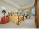 Inviting main bedroom with tray ceilings, ceiling fan, and a bay window offering a view of the backyard at 7015 Stanhope Pl, University Park, FL 34201