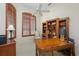 Comfortable office with wood shelves, light beige carpet, and dark wood shutters for a bright and airy feel at 7015 Stanhope Pl, University Park, FL 34201