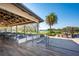 Covered outdoor seating area with wood-look flooring and views of the lake, palm trees, and golf course at 7015 Stanhope Pl, University Park, FL 34201