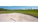 Scenic view of a lush green golf course highlighting a sand trap with a sand rake at 7015 Stanhope Pl, University Park, FL 34201