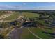An aerial view displaying the golf course, clubhouse, and parking area surrounded by mature trees and green spaces at 7024 Brier Creek Ct, Lakewood Ranch, FL 34202