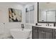 Bright bathroom features a modern freestanding tub with black faucet and plantation shutters at 7024 Brier Creek Ct, Lakewood Ranch, FL 34202
