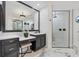 Bathroom with granite countertop vanity, framed mirror, and glass-enclosed walk-in shower at 7024 Brier Creek Ct, Lakewood Ranch, FL 34202