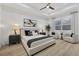 This is a bedroom with a white bed, two chairs, and a window. The walls are white and the floors are wood at 7024 Brier Creek Ct, Lakewood Ranch, FL 34202