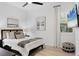 Bright bedroom featuring wood floors, ceiling fan, television, and window with white shutters at 7024 Brier Creek Ct, Lakewood Ranch, FL 34202